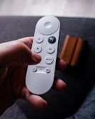 a person holding a remote control in their hand