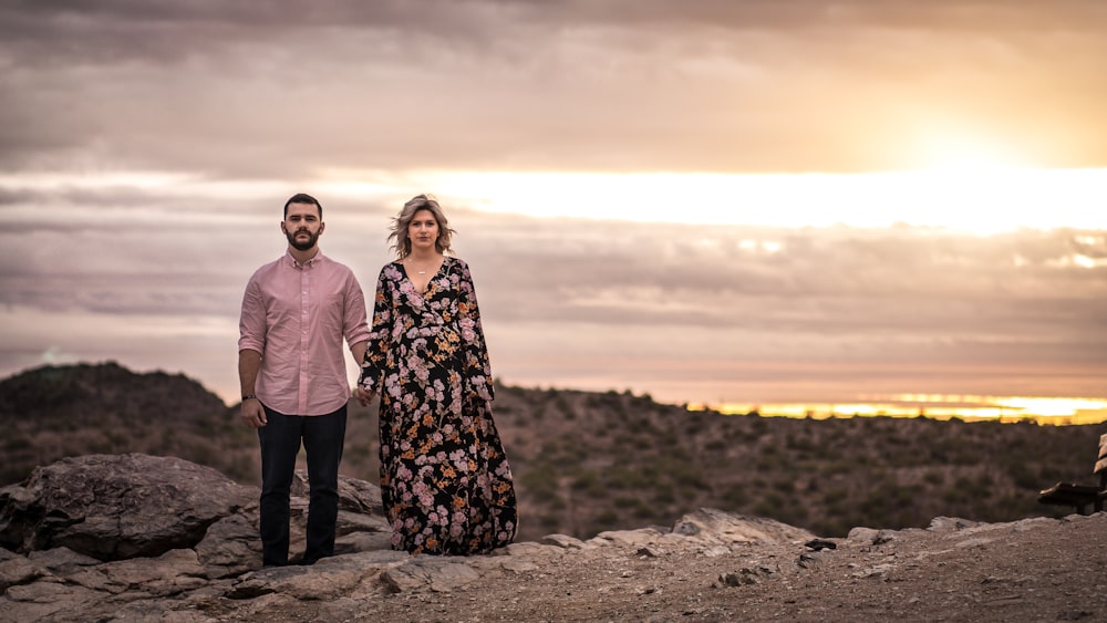 a man and a woman standing on top of a mountain