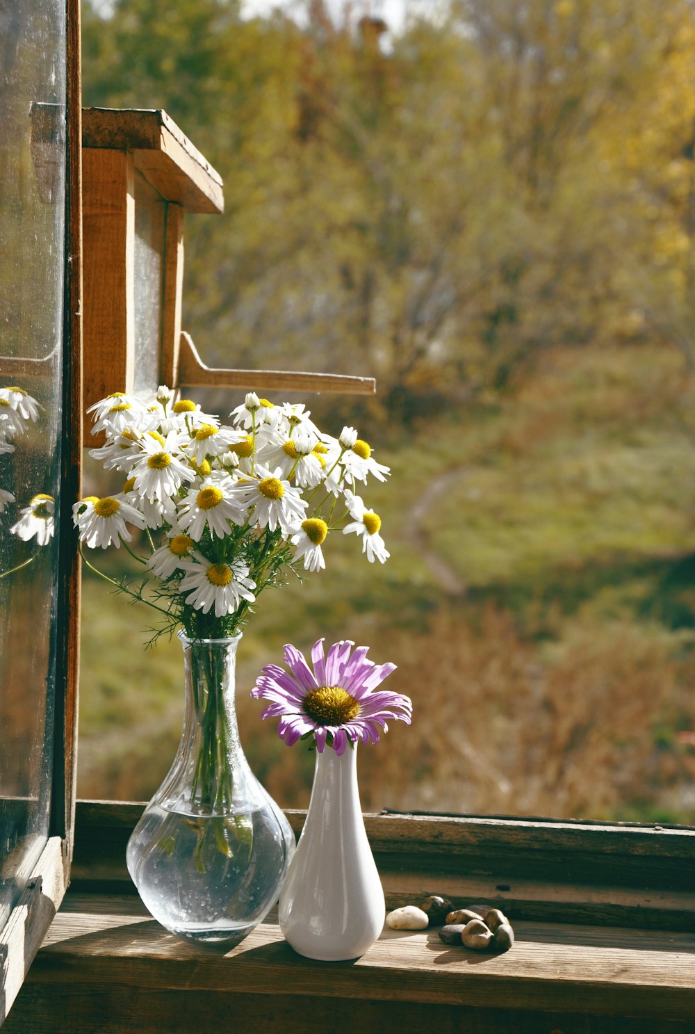 a window sill with two vases filled with flowers