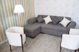 Cozy living room corner featuring vinyl flooring and soft gray curtains