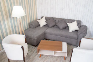 A cozy living room setup featuring a plush sofa and matching armchairs available for rent.