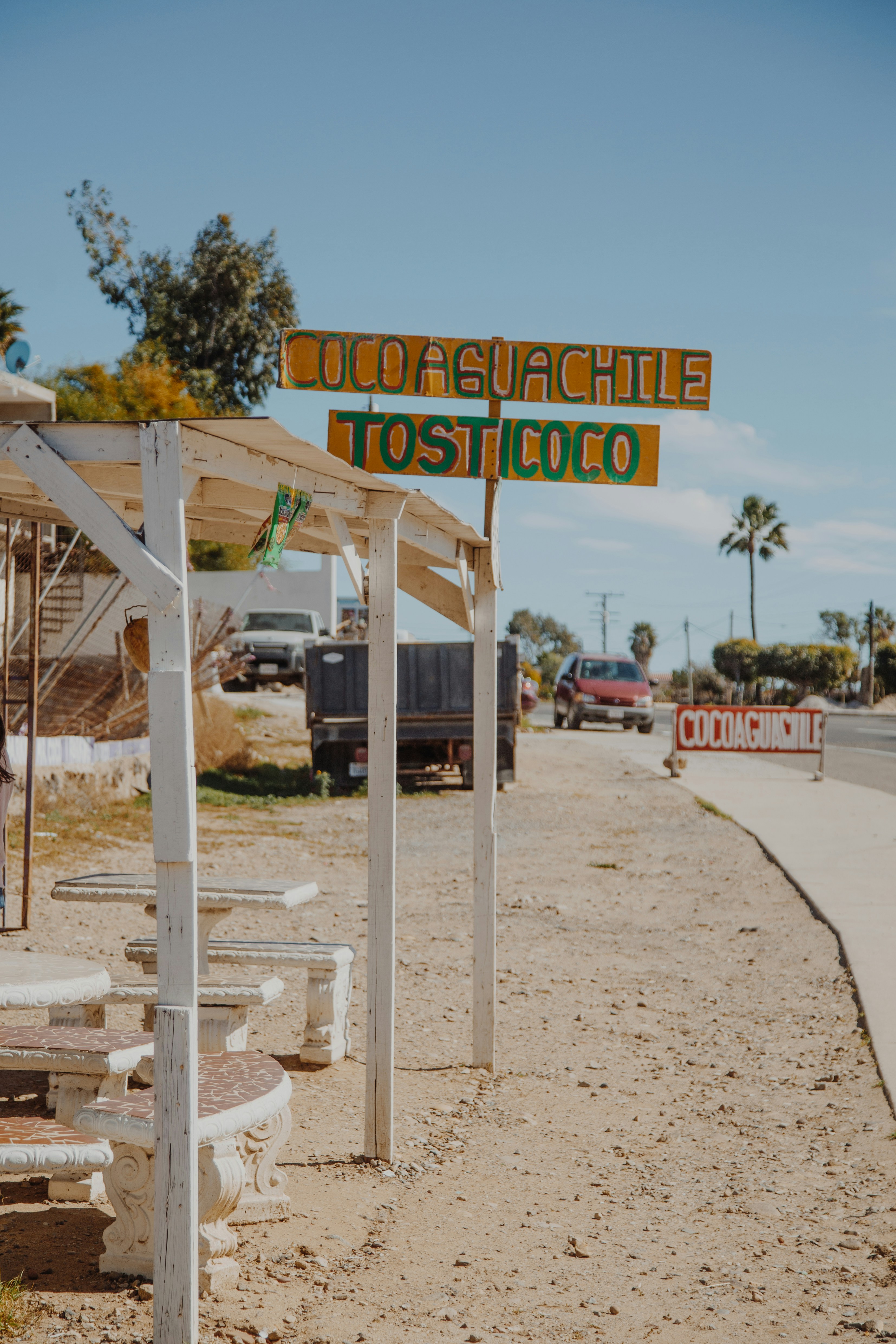 Vibrant Miami Beach restaurant exterior with outdoor seating, palm trees and colorful neon signage