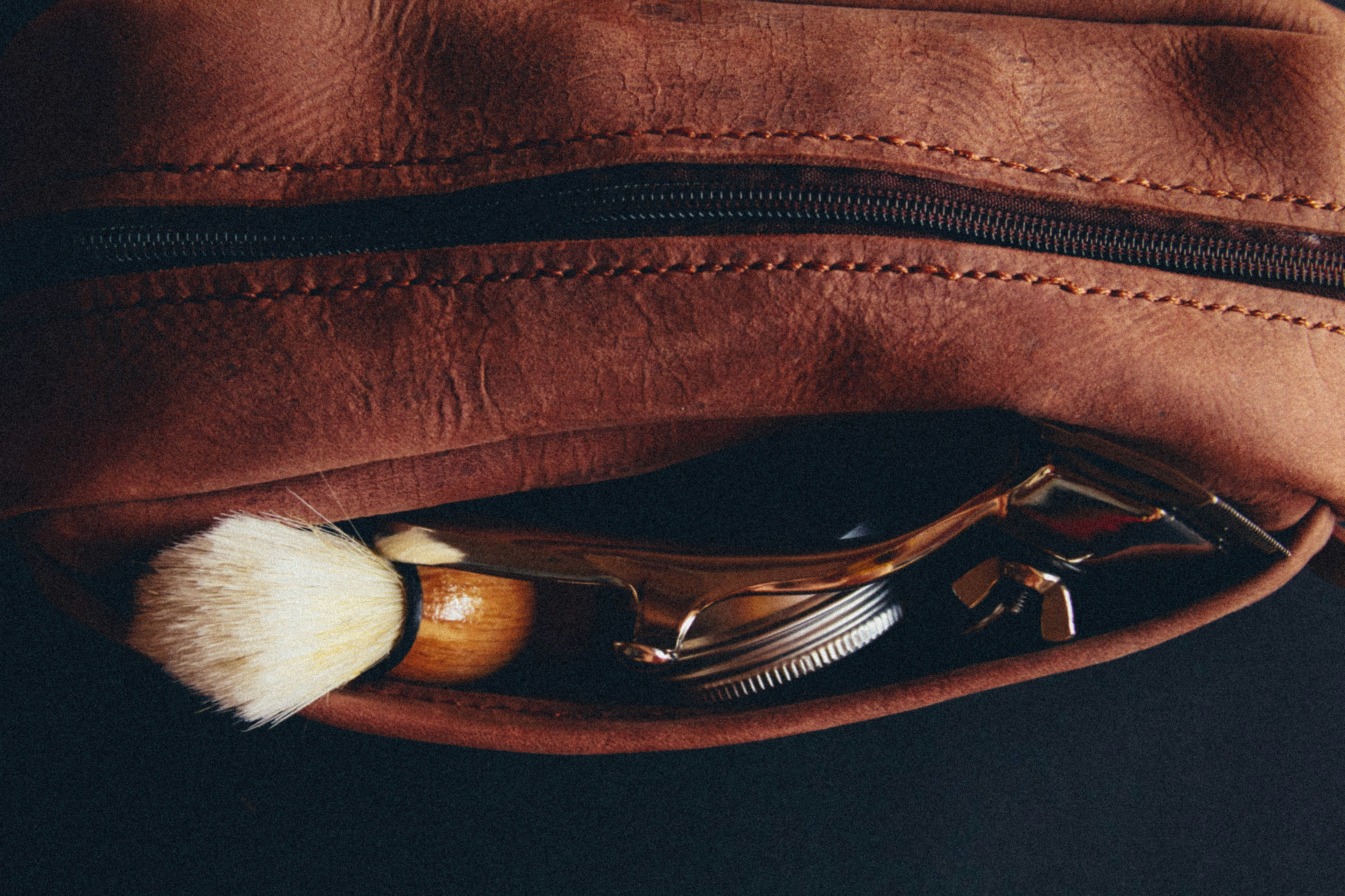 a leather pouch with a shaving brush and a razor in it, Handmade leather bag dopp kit