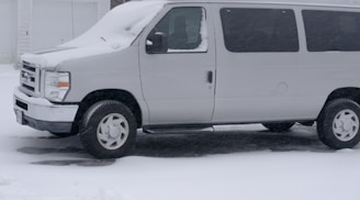 Emergency service van parked near a countryside house on a cold winter day, ready to assist.