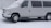 A white van is parked in a snowy environment, covered with a light dusting of snow. The snow is still falling lightly, creating a cold and wintry atmosphere.