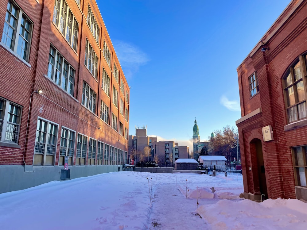 a snow covered street with buildings in the background