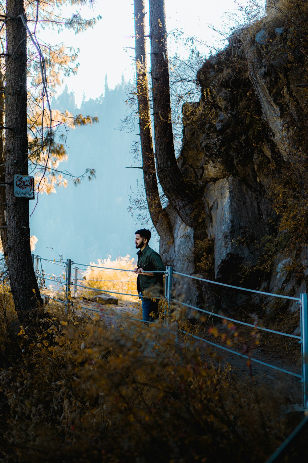 a man standing on a path in the woods