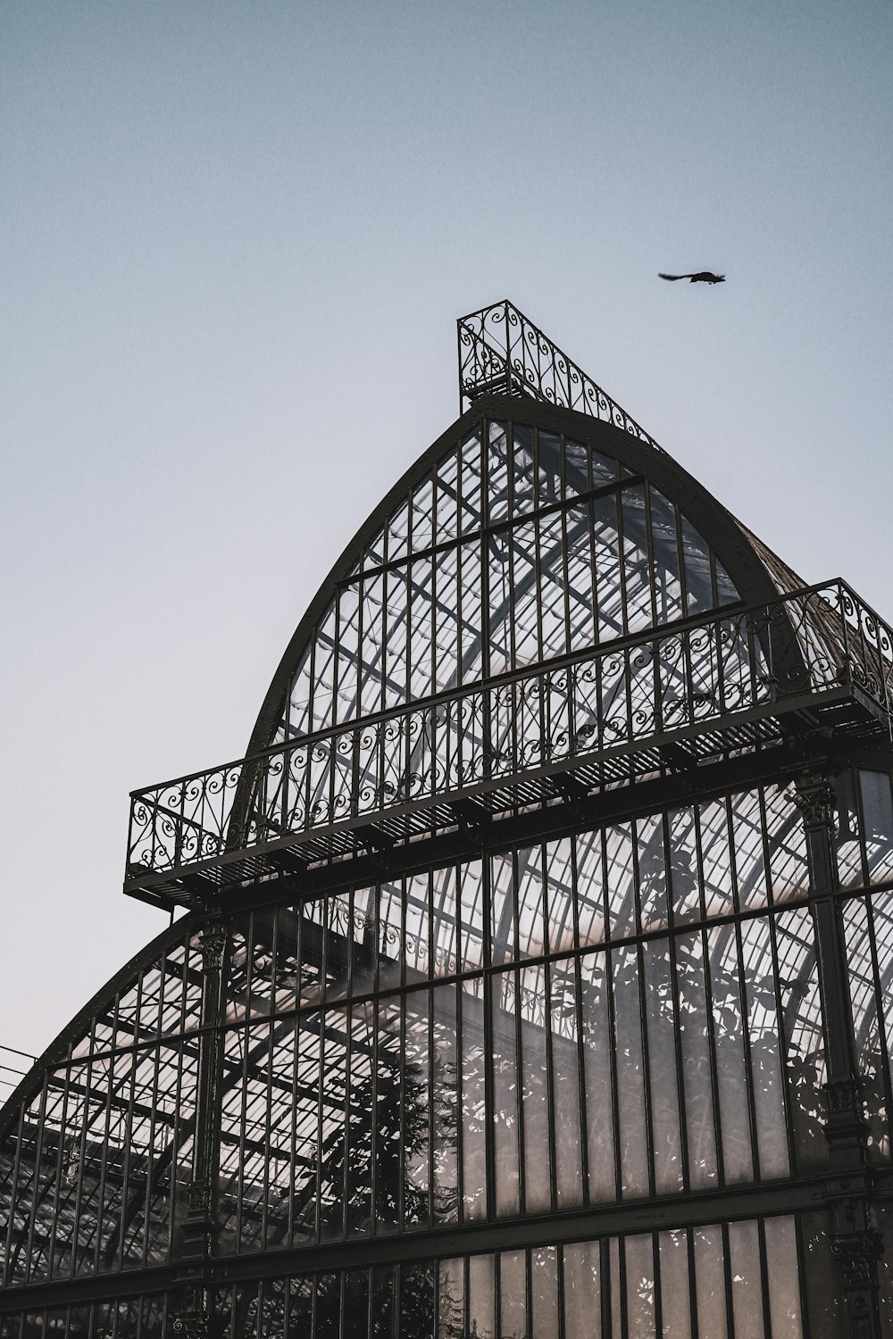 a large metal structure with a bird flying over it