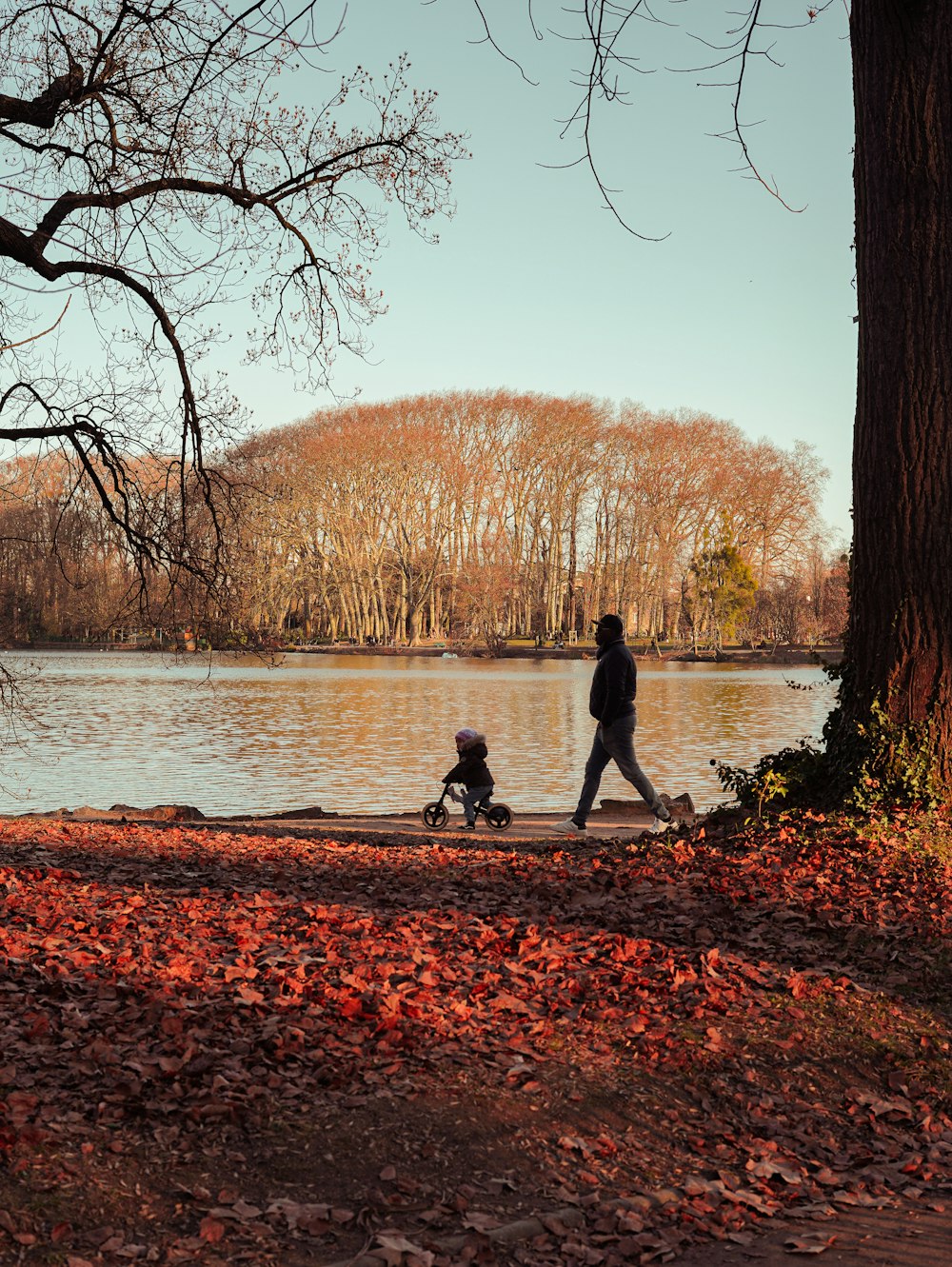 a man and a child are walking by the water