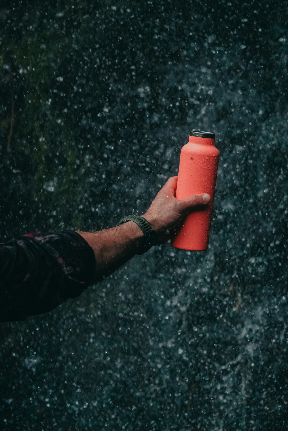 a man holding a red can in the rain