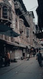a man walking down a street next to tall buildings