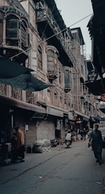 a man walking down a street next to tall buildings