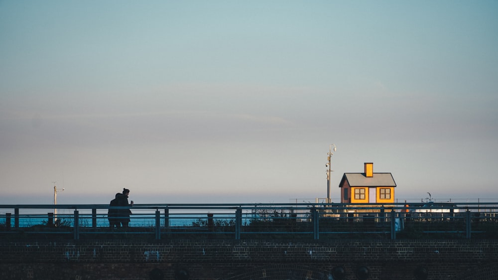 a man standing on a bridge looking at the ocean