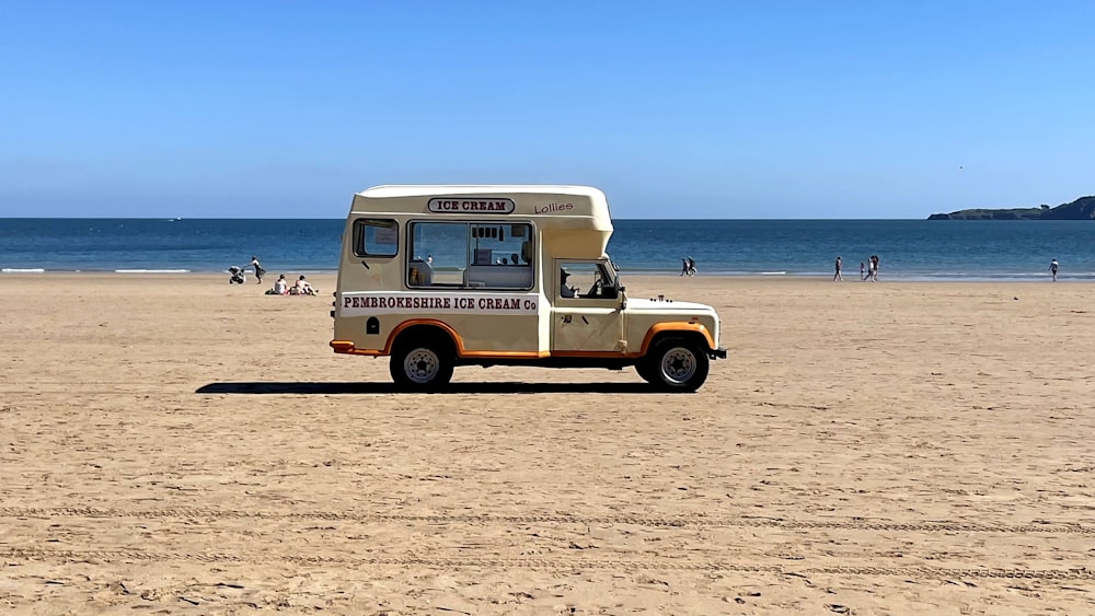 um caminhão de comida estacionado em uma praia perto do oceano