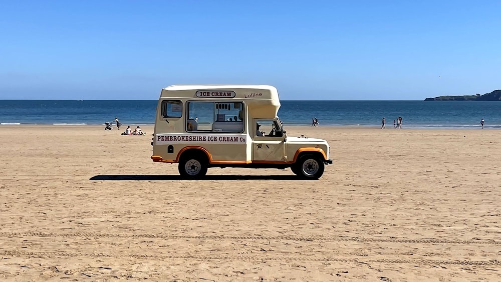 a food truck parked on a beach near the ocean