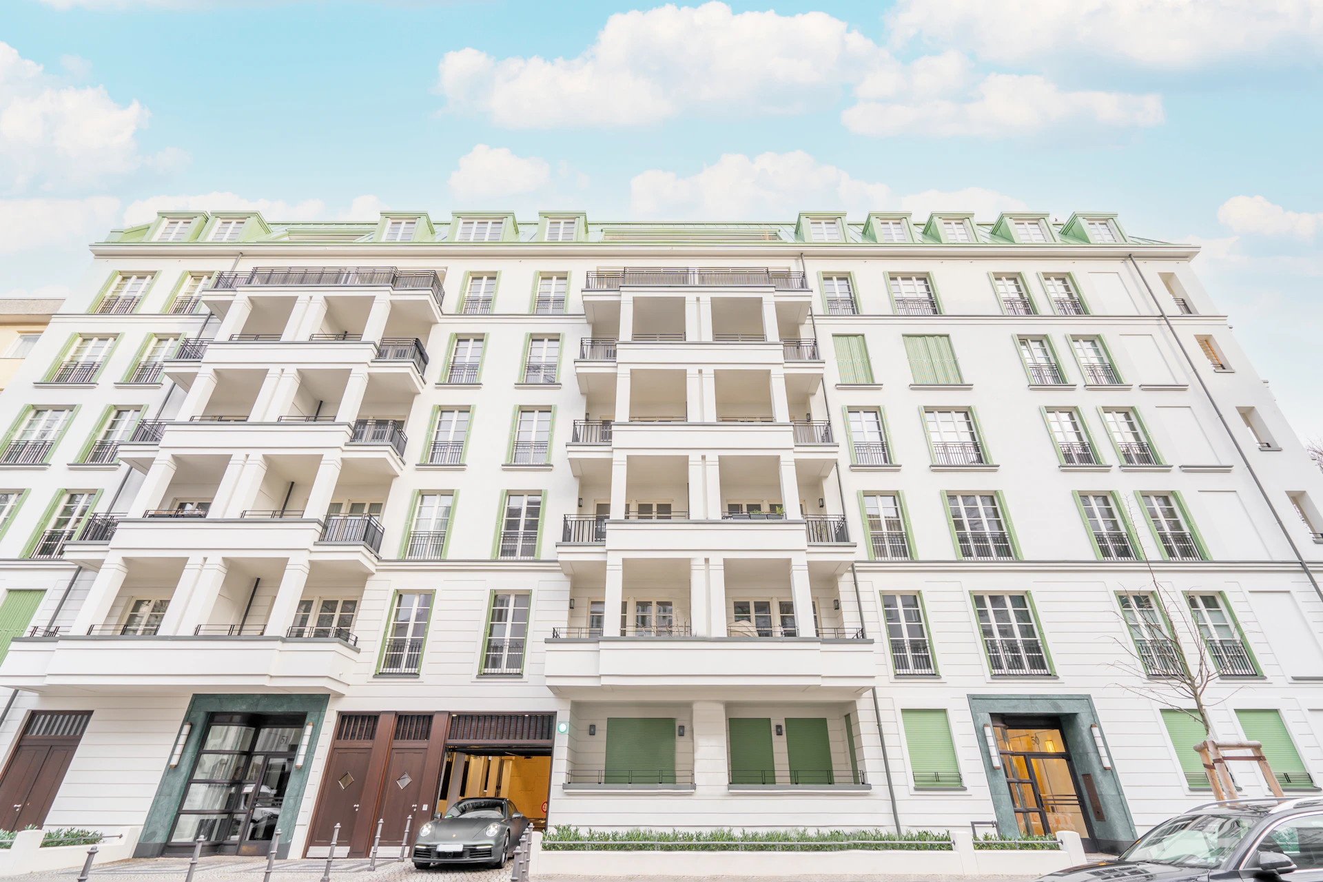 a car parked in front of a tall white building