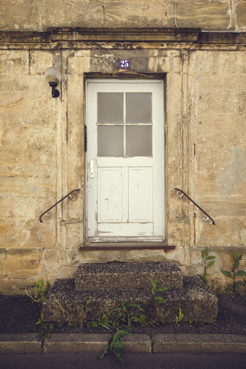 a white door sitting next to a window on the side of a building