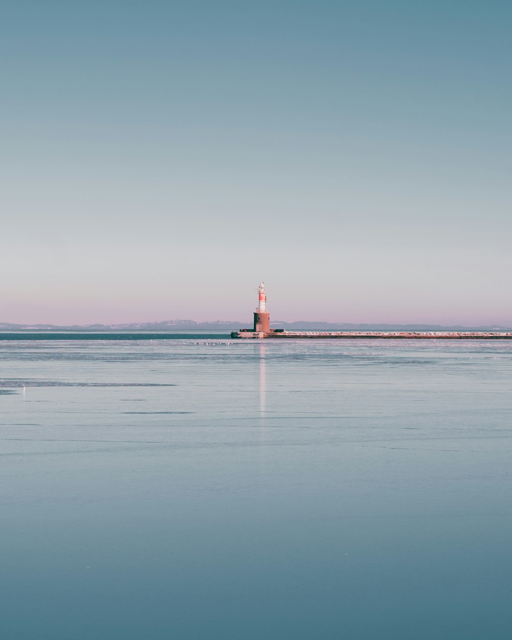 a light house sitting in the middle of a body of water