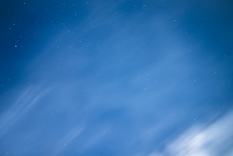 Calm and serene celestial background in pastel blue and violet hues with subtle golden highlights.