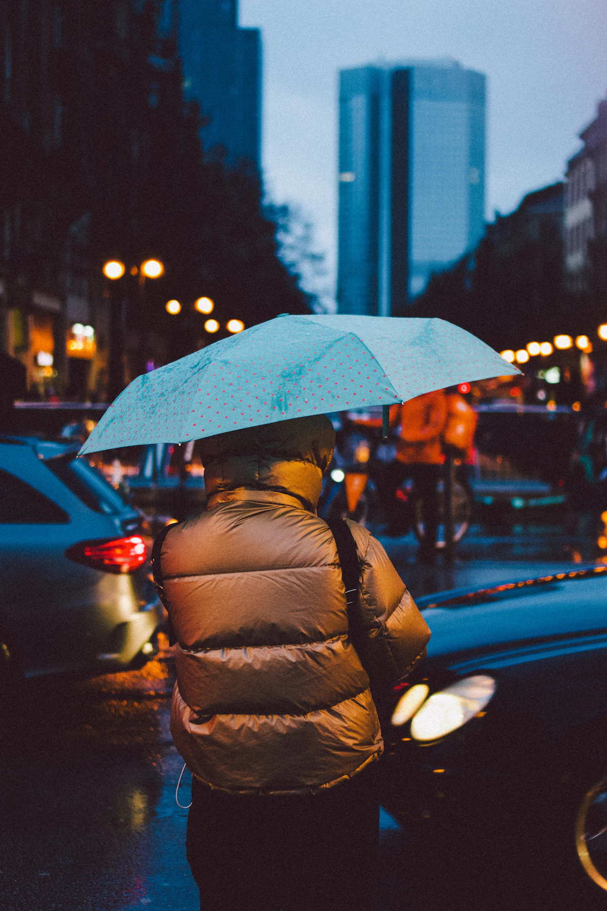 Woman with umbrella walking on rainy city street