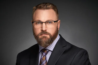 a man with a beard wearing a suit and tie