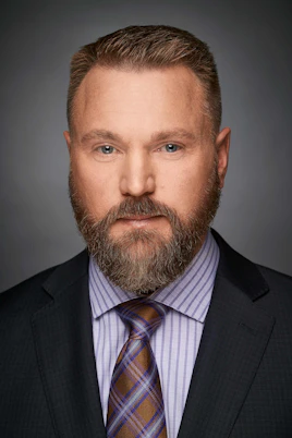 a man with a beard wearing a suit and tie