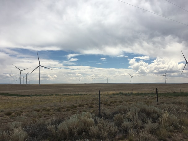 Vast open land combining solar panels and wind turbines, representing hybrid energy potential.