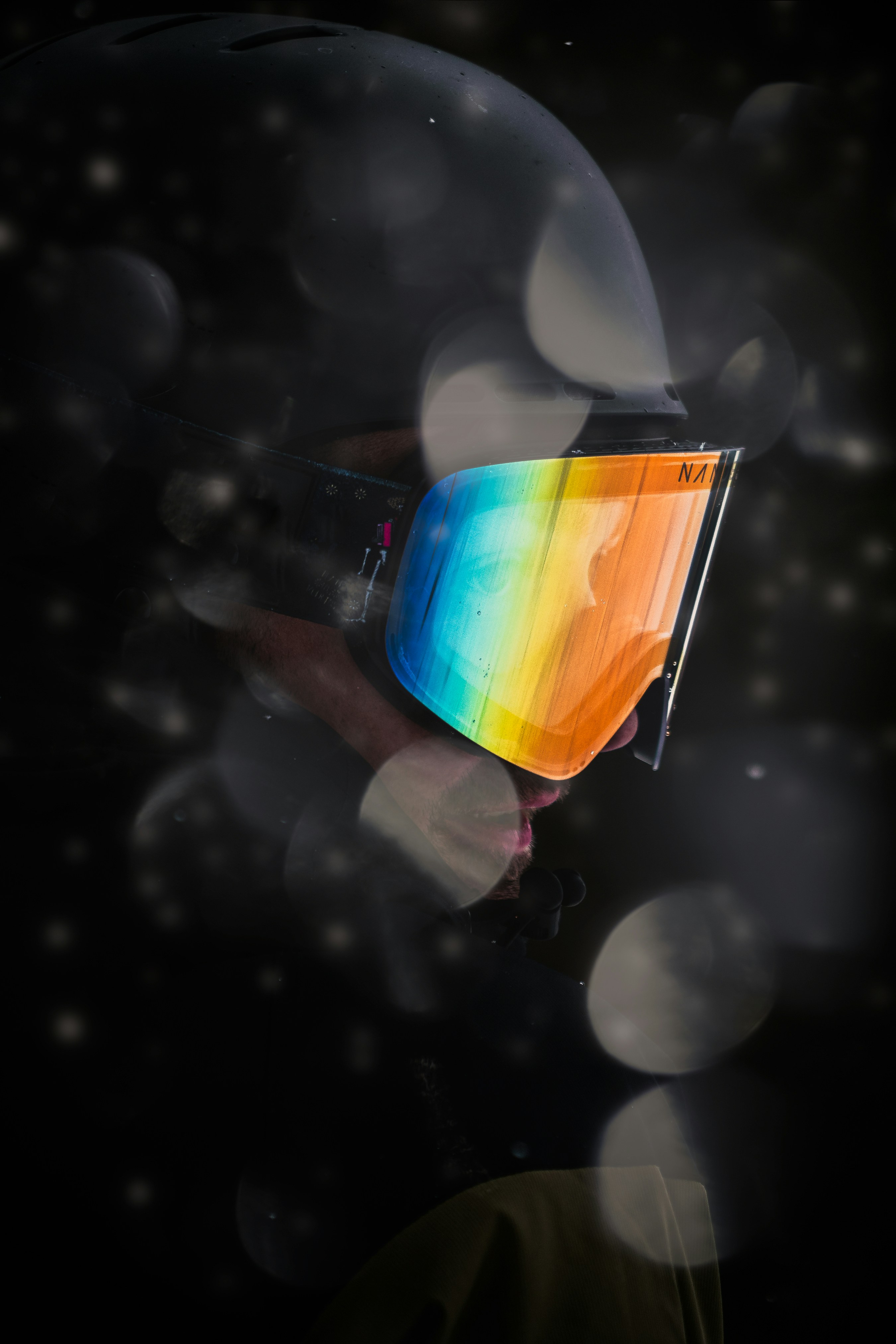 a person wearing a helmet with a rainbow reflection on it