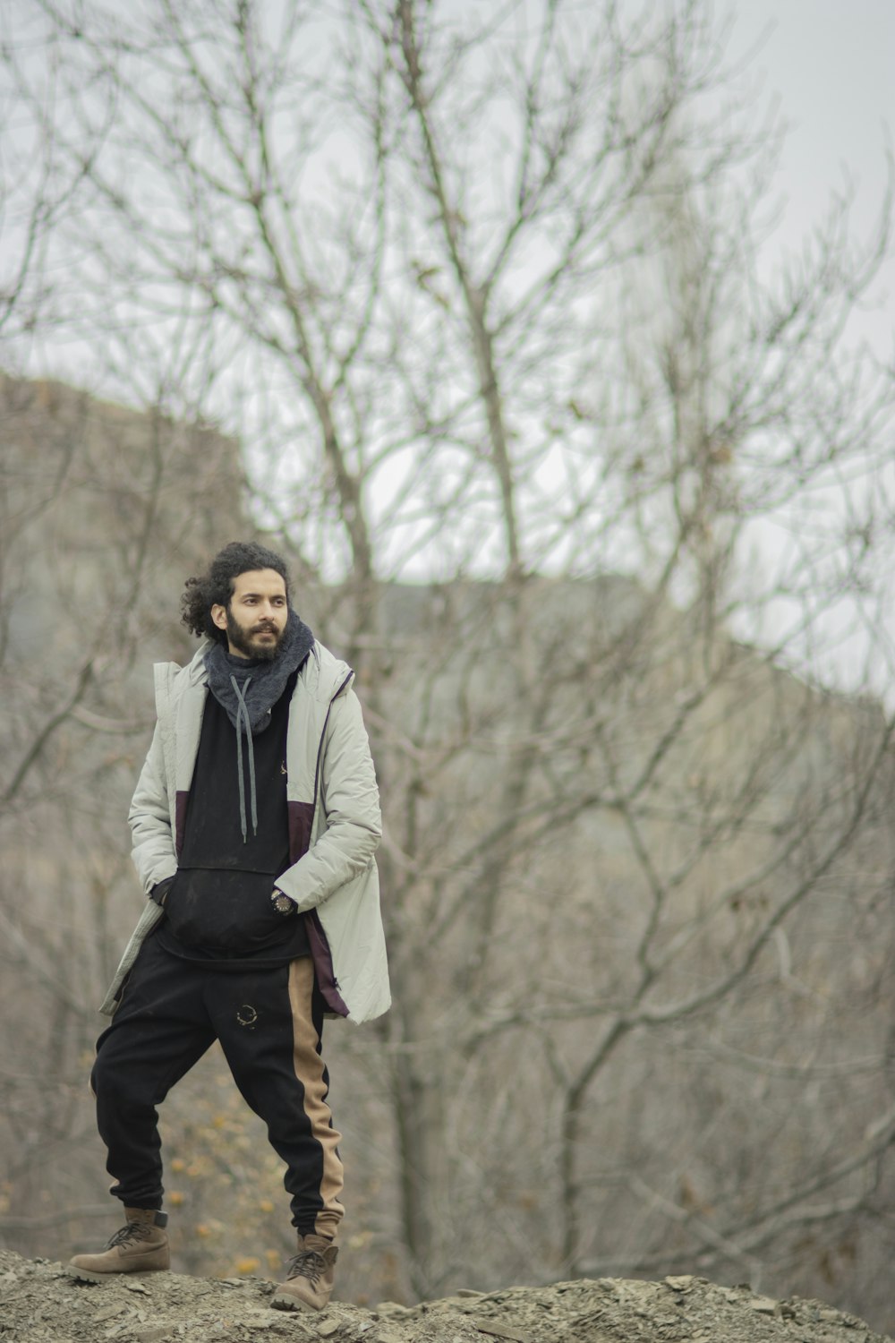 a man standing on top of a rock next to a forest