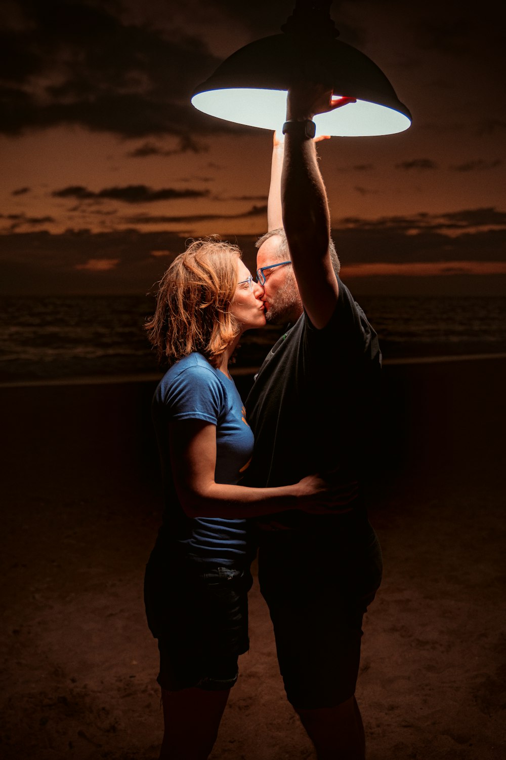 a man and a woman kissing under a light