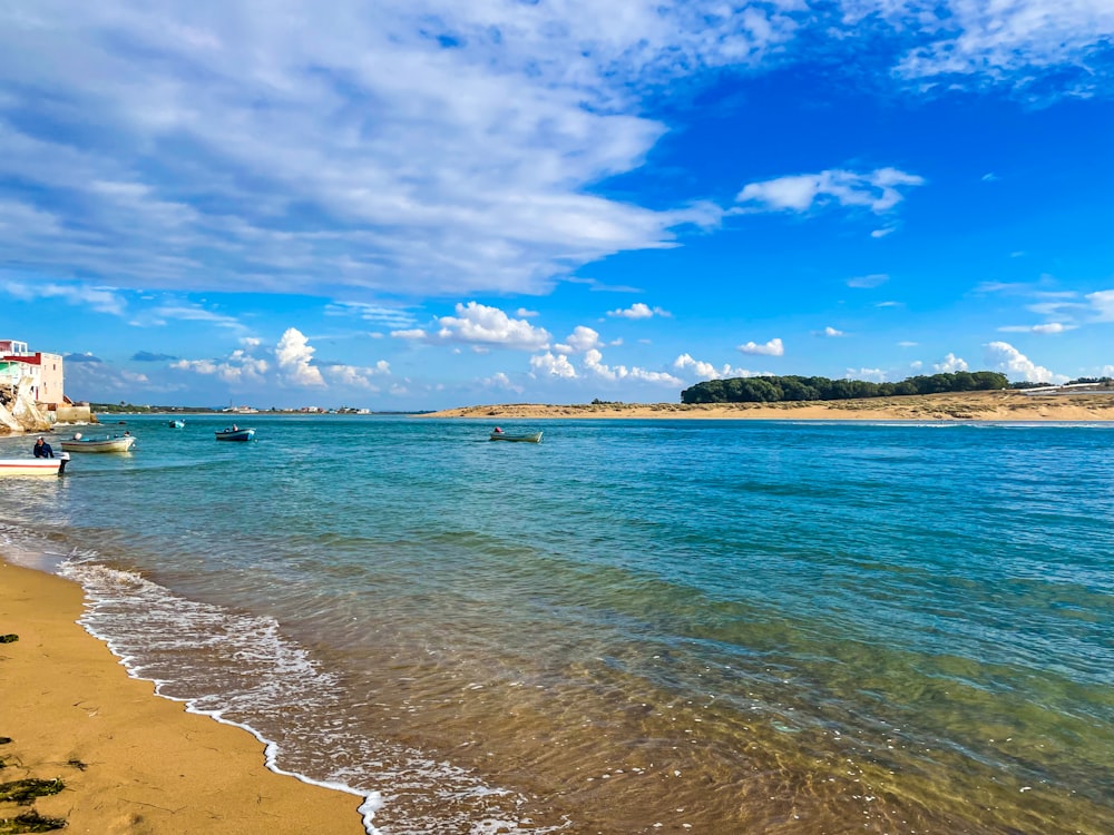 une plage de sable avec des bateaux dans l’eau