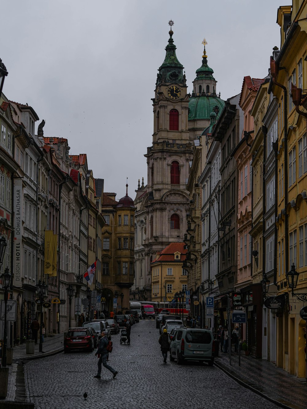 a person walking down a cobblestone street in a city