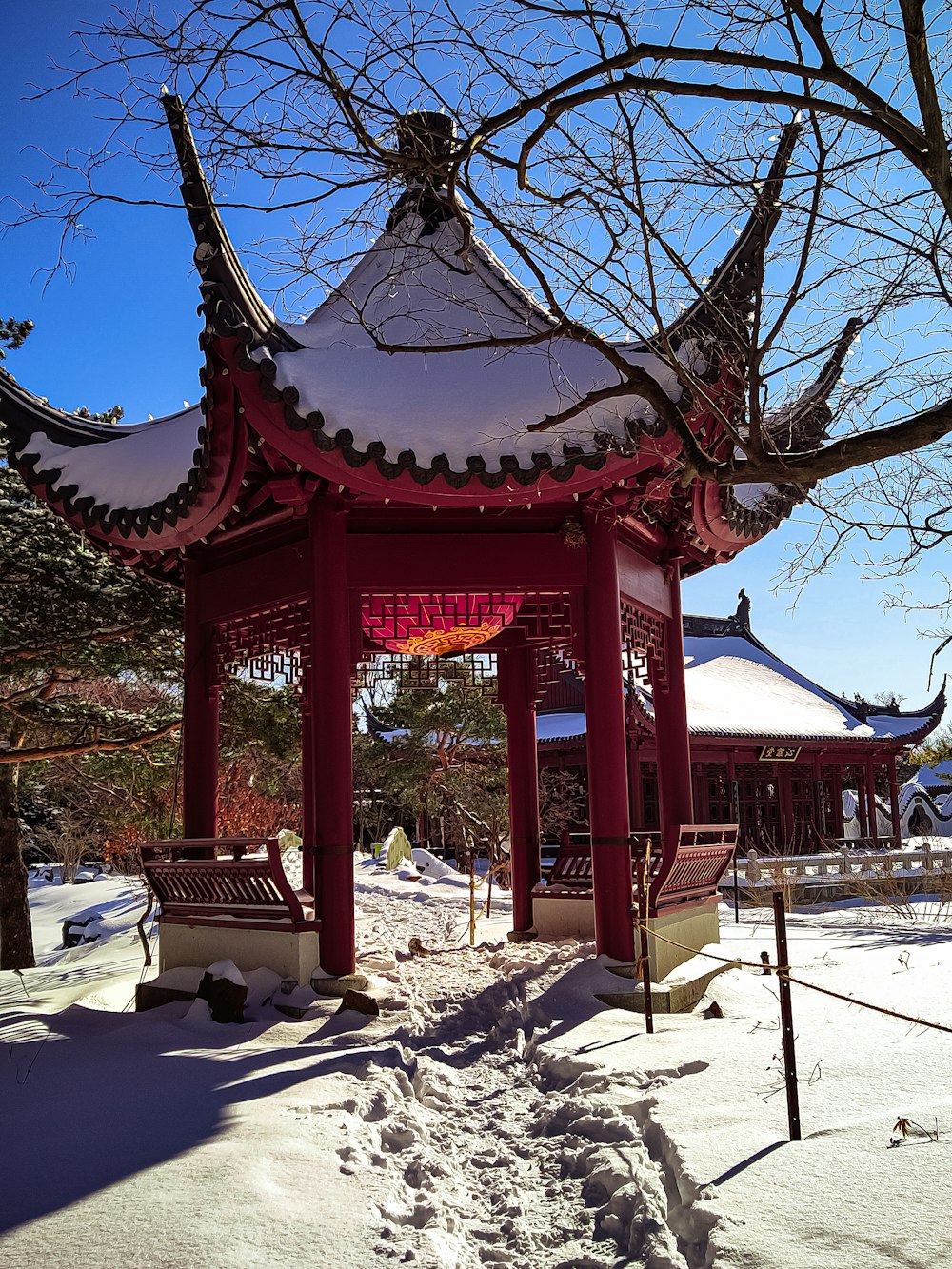 a red gazebo in the middle of a snowy park