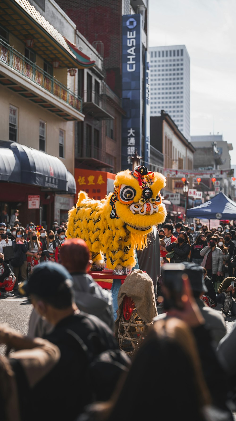 a parade with a large yellow lion float in the middle of the street