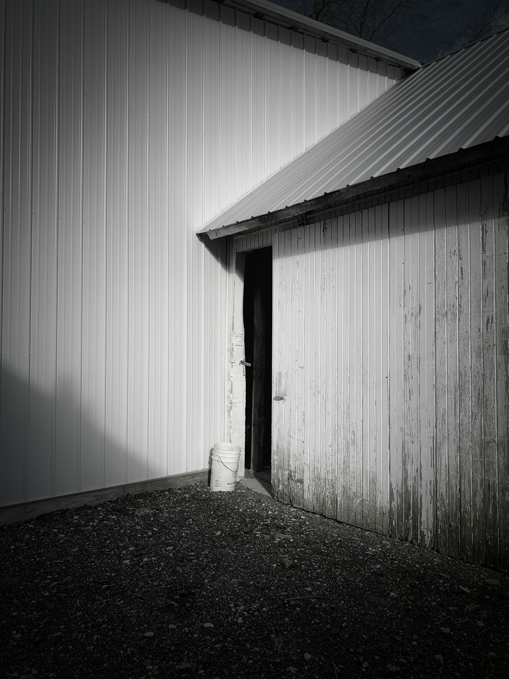 a white building with a metal roof and a door