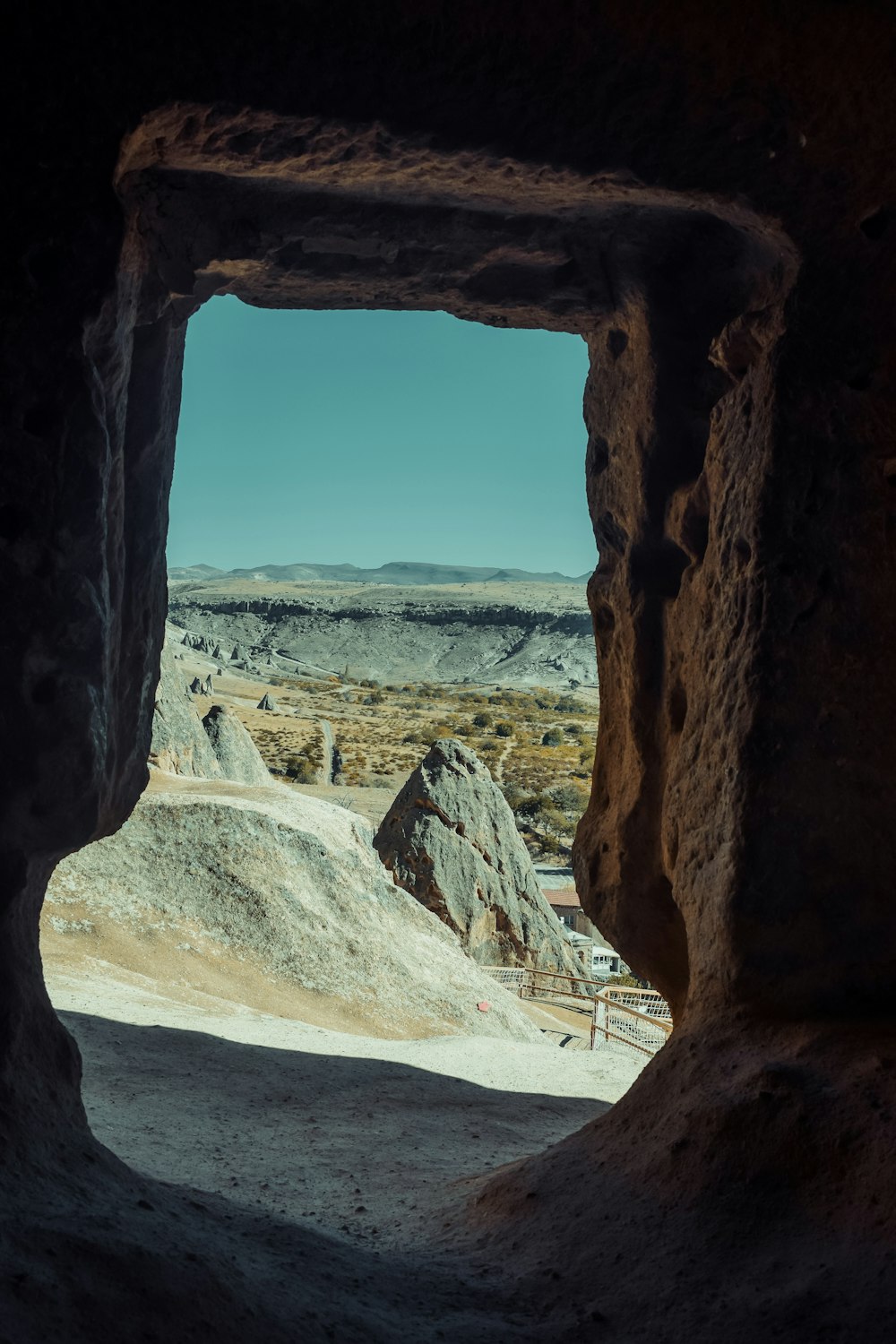 a view from inside a cave looking out into the desert