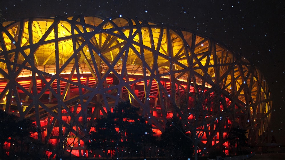 a large building lit up at night in the snow