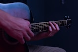 Hands strumming an acoustic guitar during a live recording session.