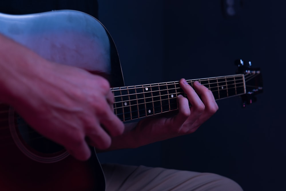 Eine Person, die in einem dunklen Raum Gitarre spielt