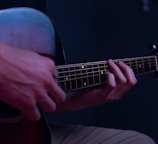 a person playing a guitar in a dark room