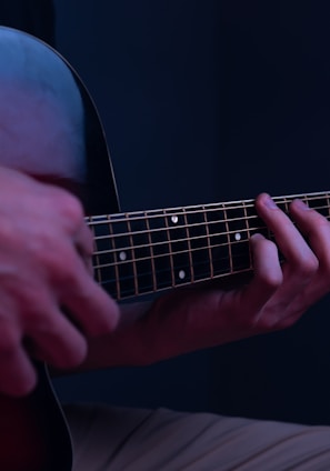 a person playing a guitar in a dark room