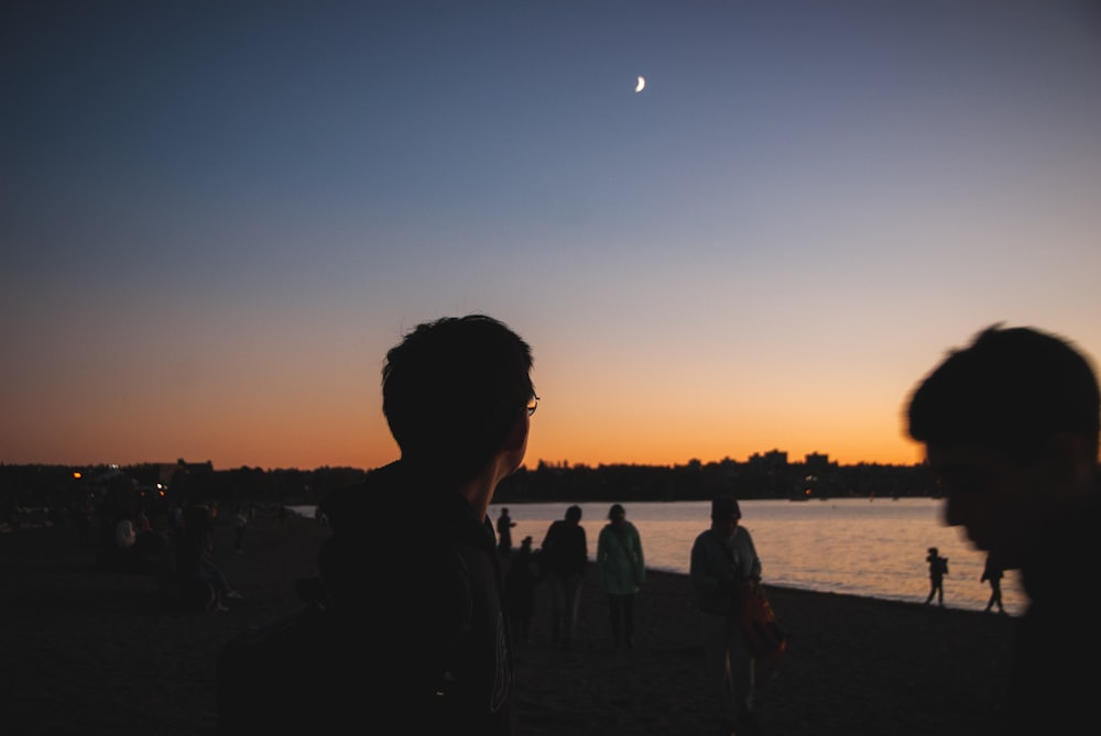 a group of people standing on top of a beach