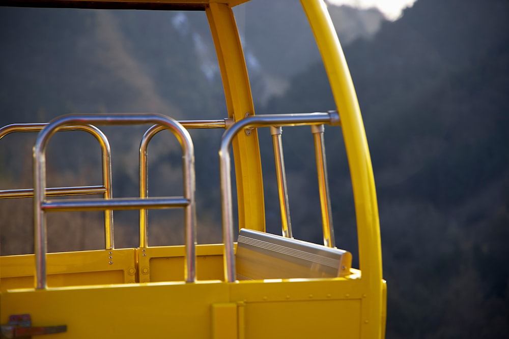 a close up of a yellow bus with a mountain in the background
