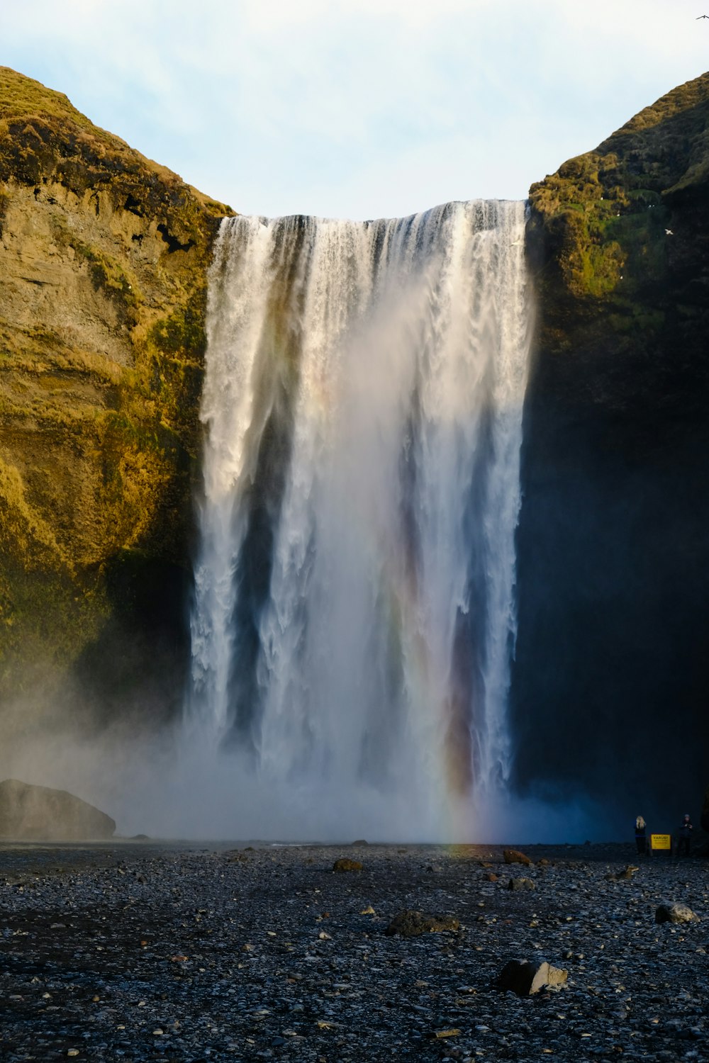 a large waterfall with a rainbow in the middle of it