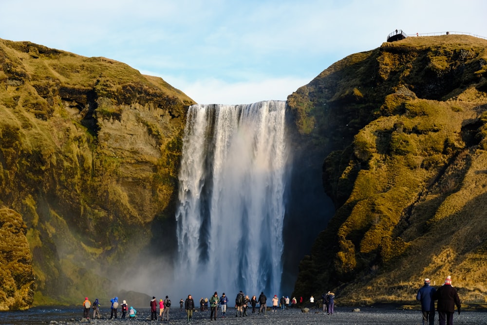 a group of people standing in front of a waterfall