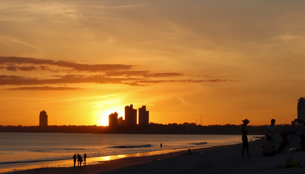 a group of people standing on top of a sandy beach