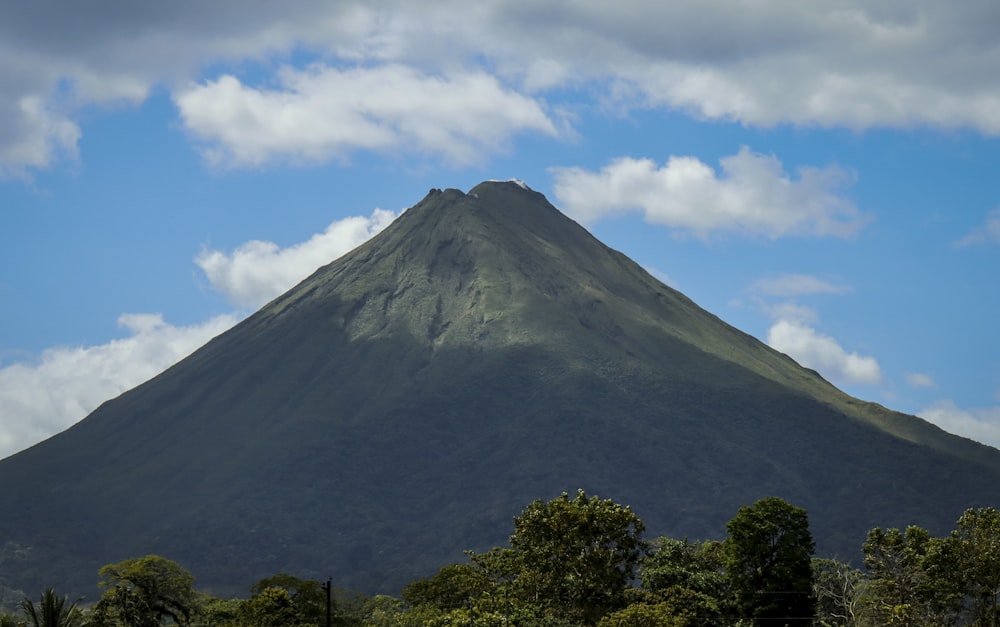 a very tall mountain with some clouds in the sky