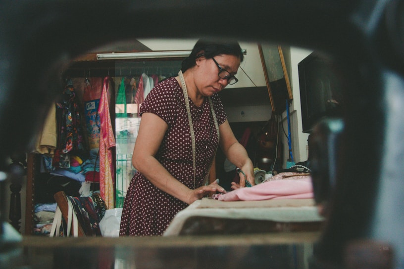 A tailor carefully measuring fabric for a custom garment.