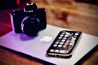 a cell phone sitting on top of a laptop computer