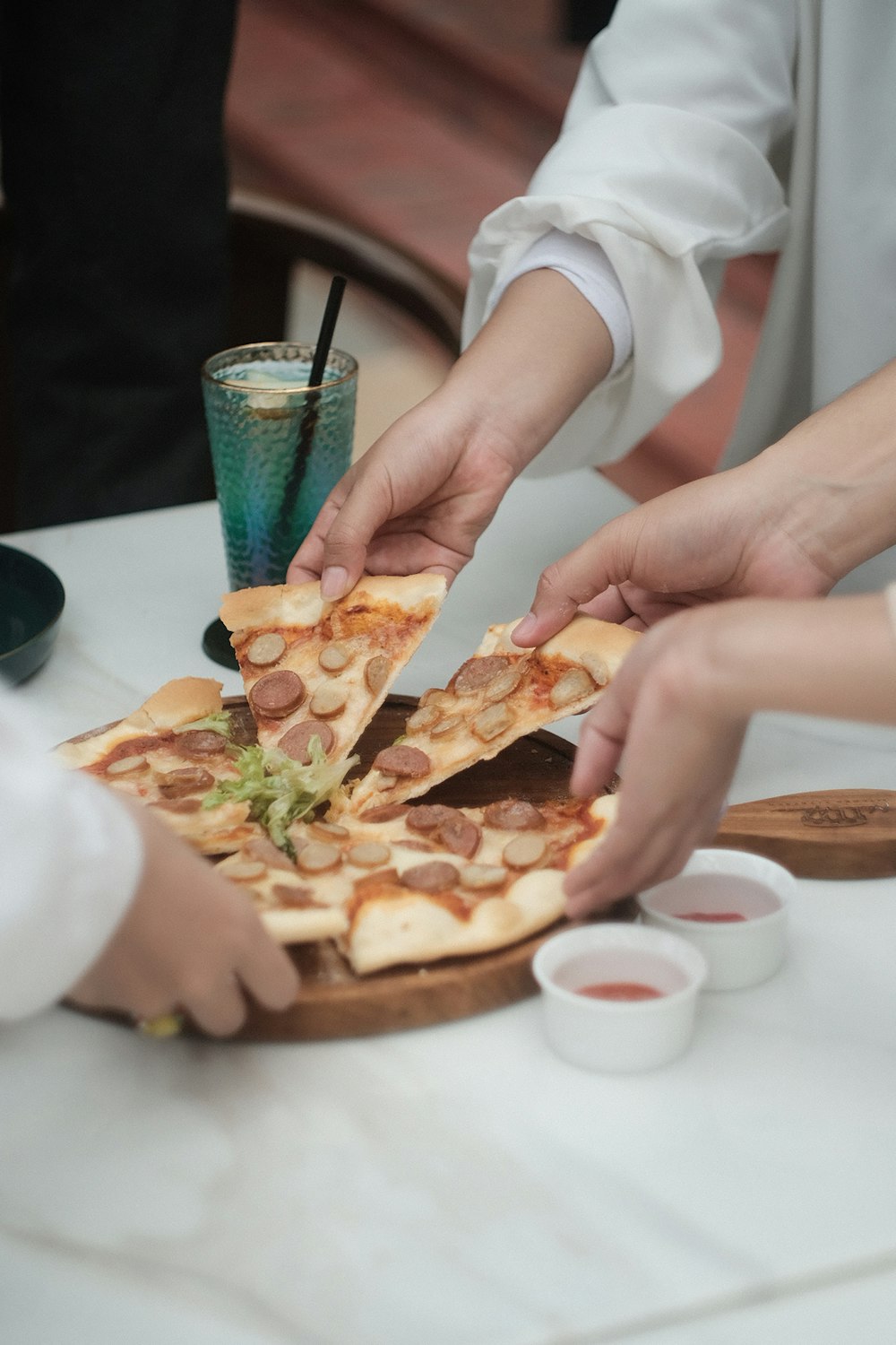 a group of people grabbing slices of pizza